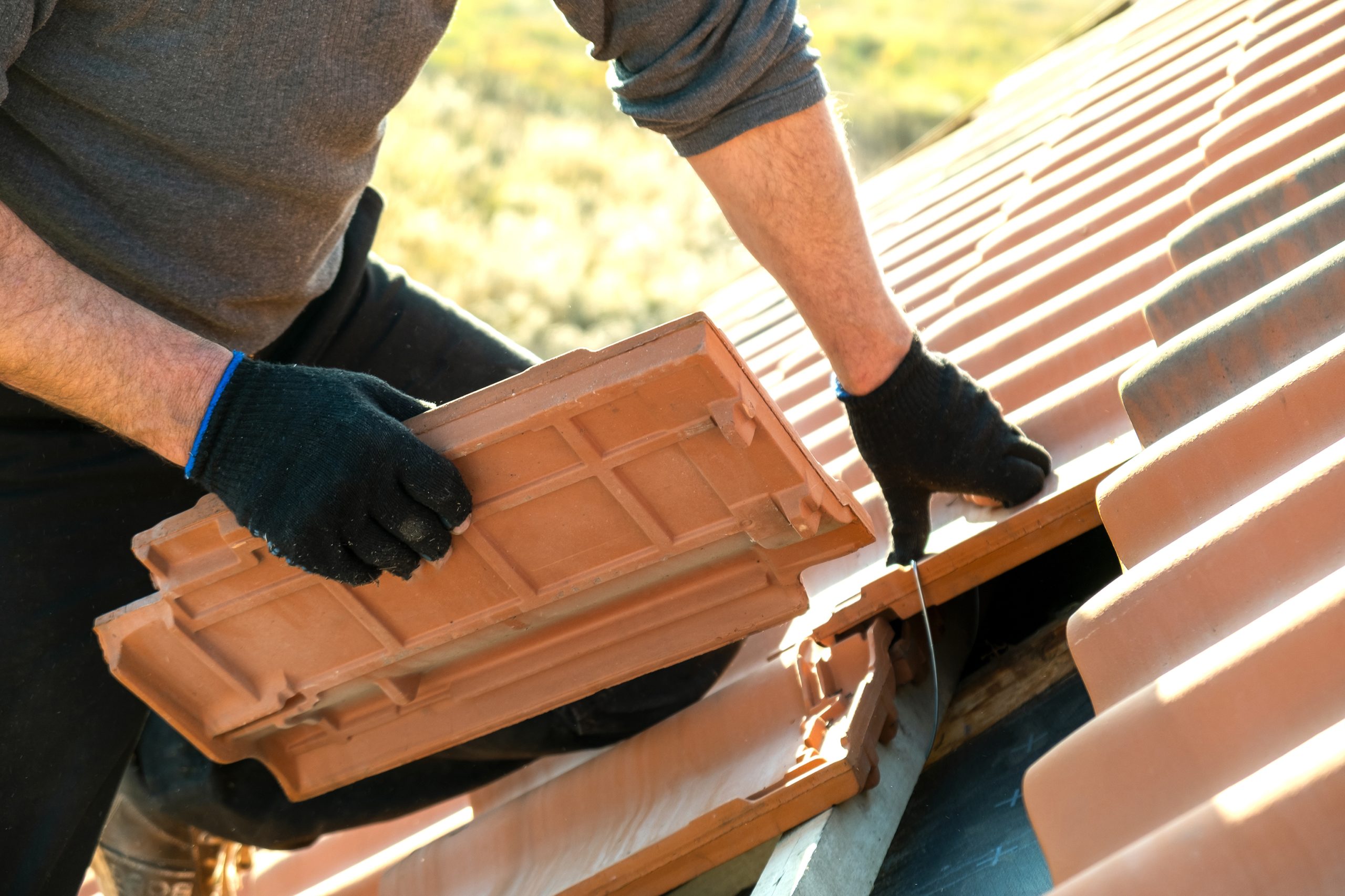 Roofer laying new roof tiles for repair